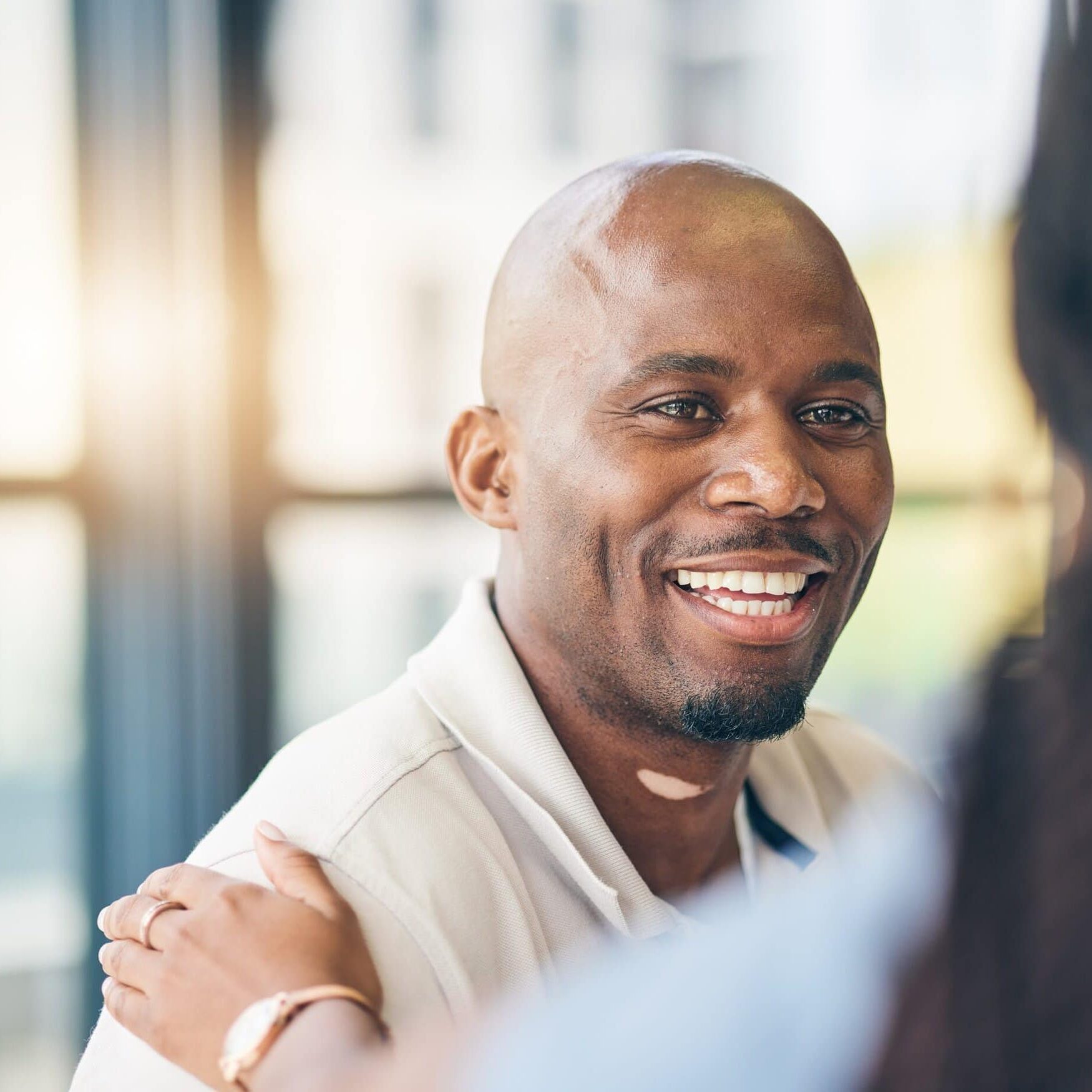 Professional smiling during a friendly conversation in an office setting