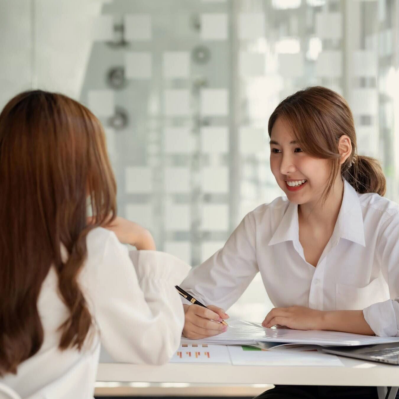 Two women go over the latest ESG report from ICF.