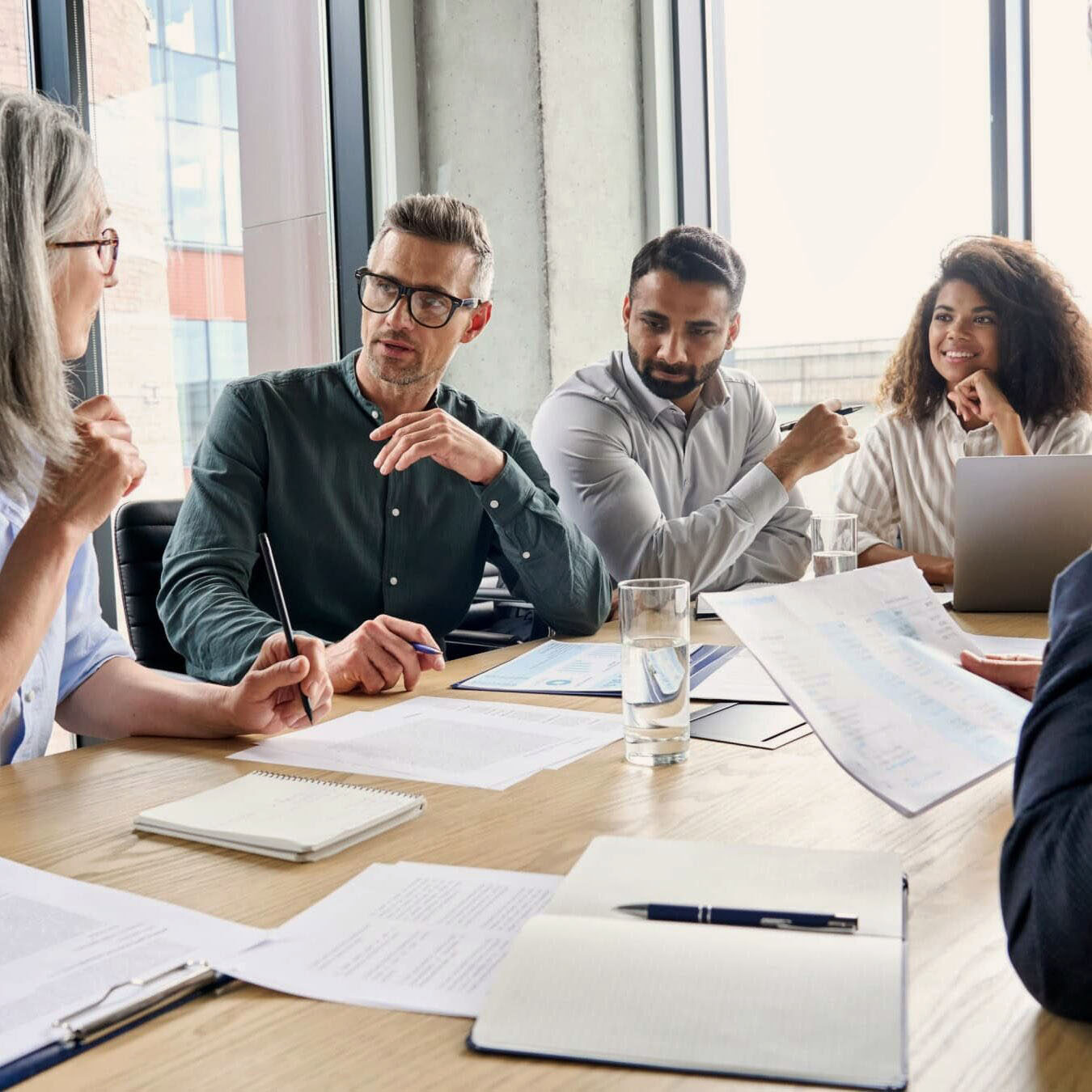 A group of people work together in an office setting at a table