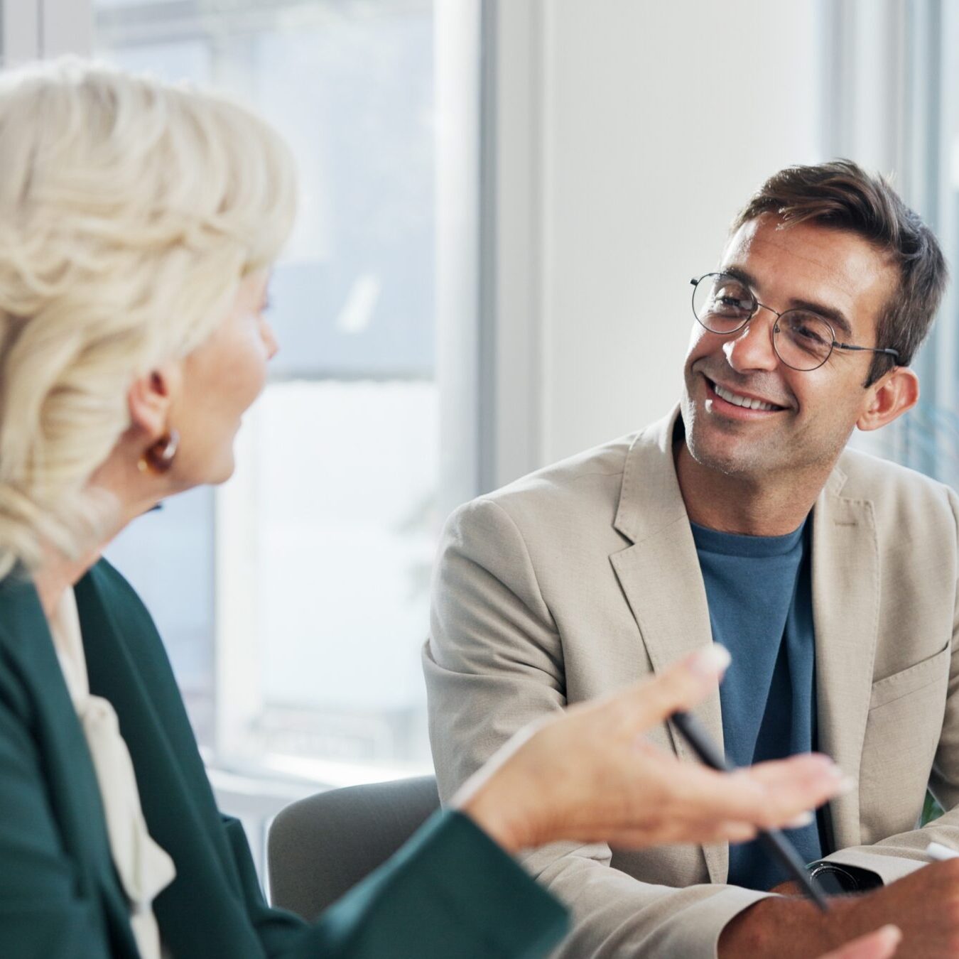 Two professionals engaged in a face-to-face meeting in a bright office