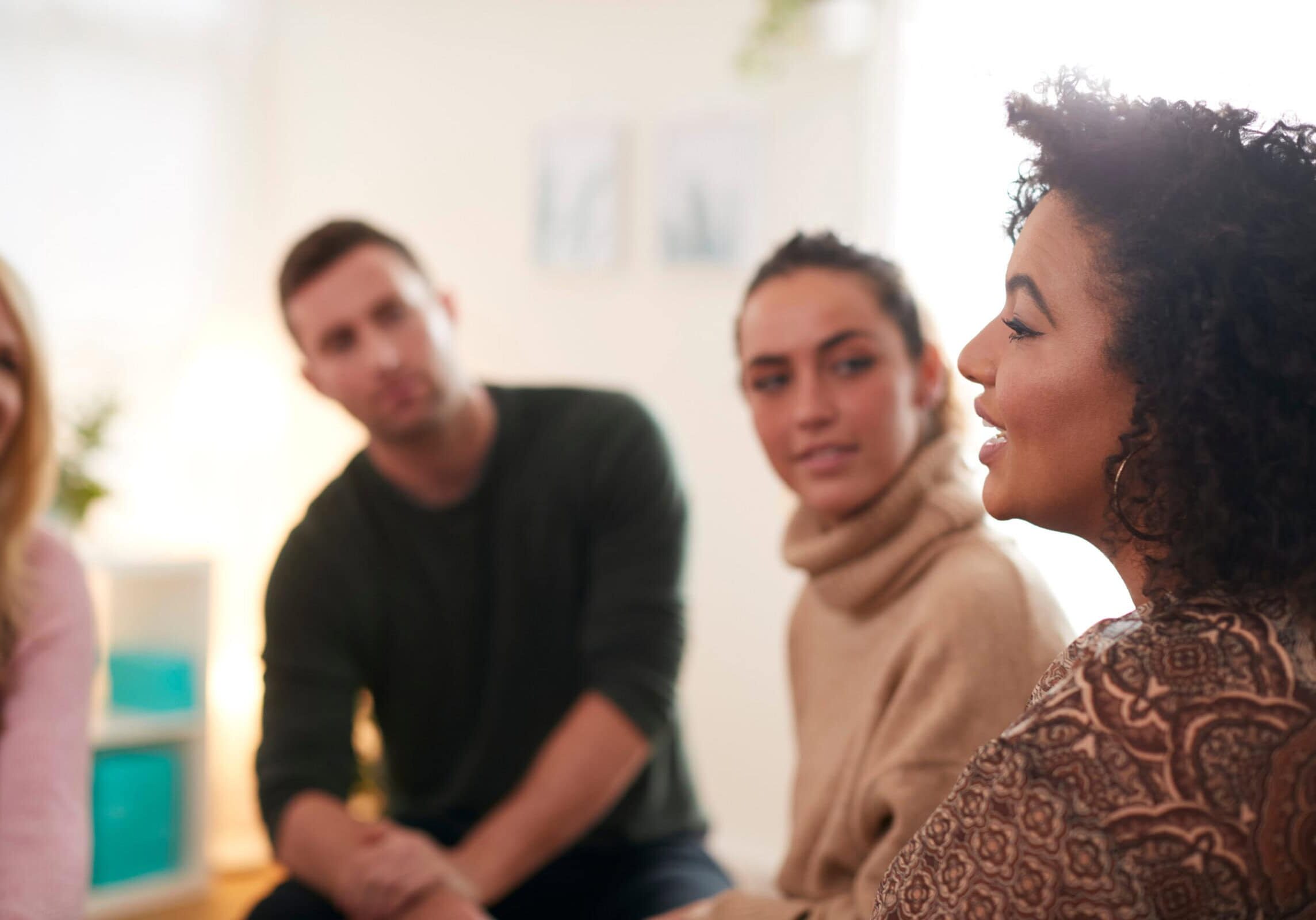 Woman speaking while others listen in small group meeting