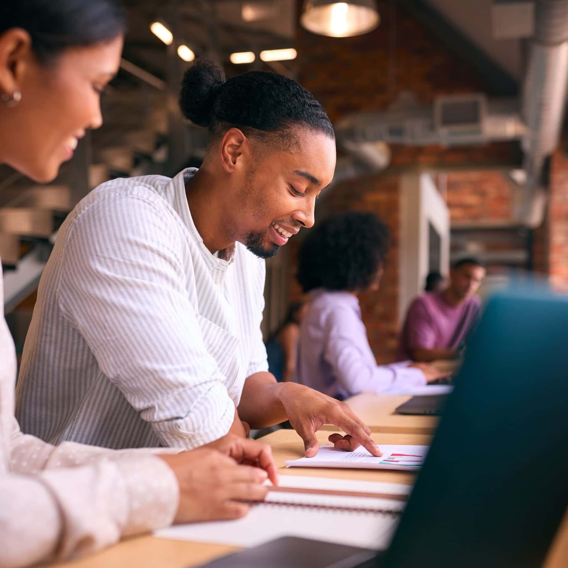 Male and female professionals reviewing documents together during a collaborative office meeting