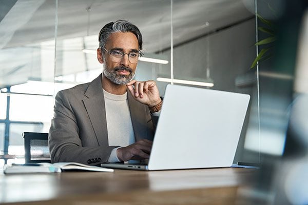 coach using a laptop at a table in an office